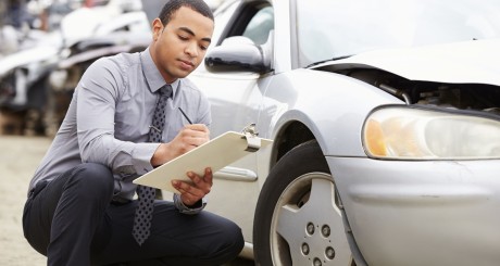 an auto claims adjuster inspecting a car after an accident