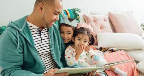 a father reading with his two daughters