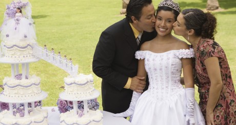 a young woman being kissed on the cheeks by her parents during her Quinceañera party