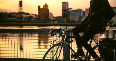 una bicicleta montando sobre el agua con el horizonte de una ciudad al fondo