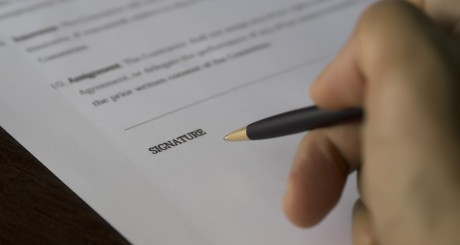 a businessperson signing a document