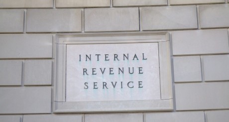 a stone wall outside the Internal Revenue Service building with a sign on it