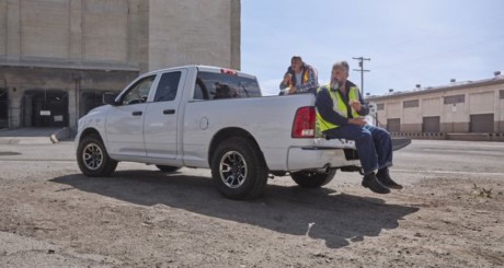 two construction workers sitting on the tailgate at a job site