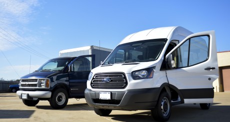 a white commercial van next to a blue commercial van