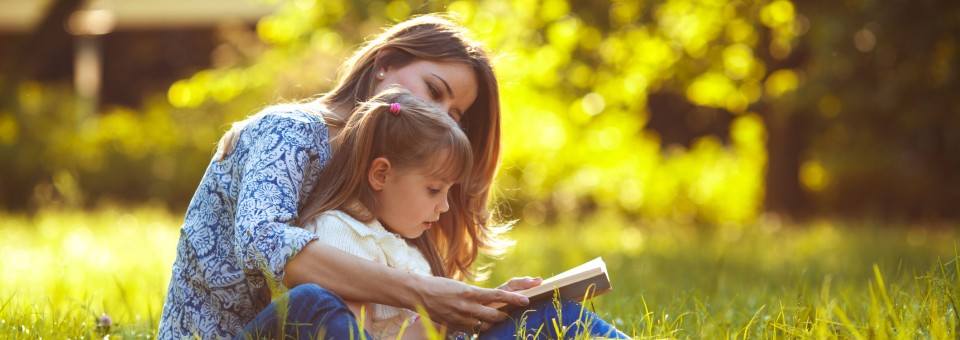 mom-reading-to-daughter-outside
